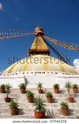 bodhnath stupa in Kathmandu with buddha eyes and prayer flags on clear blue sky background