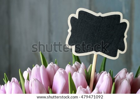 Bouquet of pink tulips and blank blackboard label , copy space