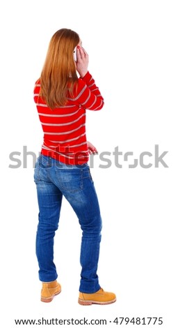 back view of a woman talking on the phone. blonde in a red striped jacket is talking on the white smartphone.