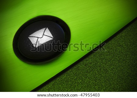 Close-up photograph of a computer keyboard mail button, tinged in green. Vignetting applied in post processing for effect.