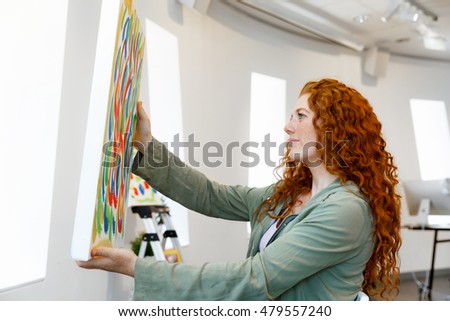 Young female artist with her picture