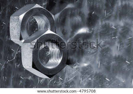 two large industrial nuts, bolts against aluminum and in a metallic blue tone