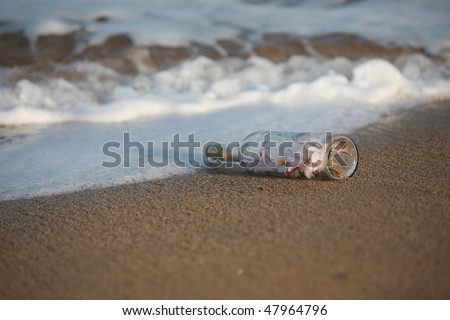 "message in a bottle" in the sand  filled with plumeria flowers