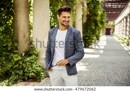 Cheerful smiling young male model in white shirt  Royalty-Free Stock Photo #479672062