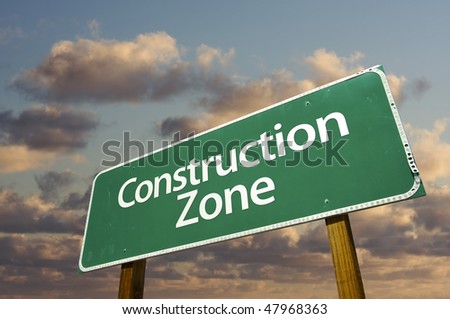Construction Zone Green Road Sign In Front of Dramatic Clouds and Sky.