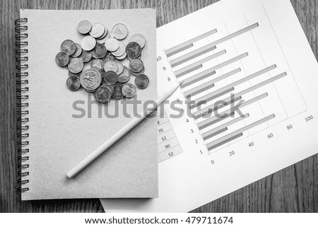 graph and note book on the wooden table with black and white color 