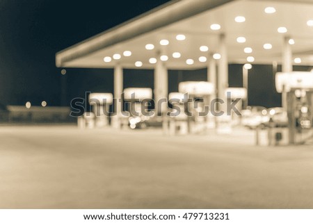 Blurred image of gas station at night. Defocused, out of focus gas station and convenience store in evening twilight. Abstract blur petrol station background with copy space. Vintage filter look.