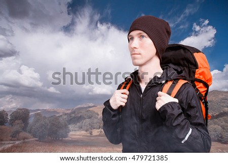 Man hiker on the background of mountain landscape with large cumulus cloud.
