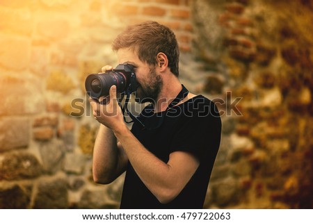 Young men boy close up photographer taking photo with holding digital camera in the nature on the summer sun