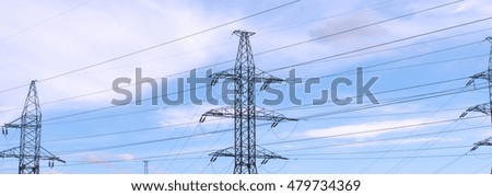 Electrical power pylons in bright blue sky