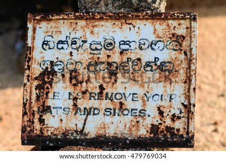 Signage to remove your hat and shoes at the UNESCO world heritage site of the ancient city of Polonnaruwa, in North Central Province, Sri Lanka. it's the second most ancient kingdoms