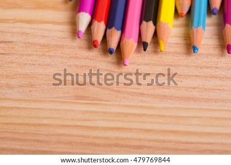 colored pencils on the wooden background