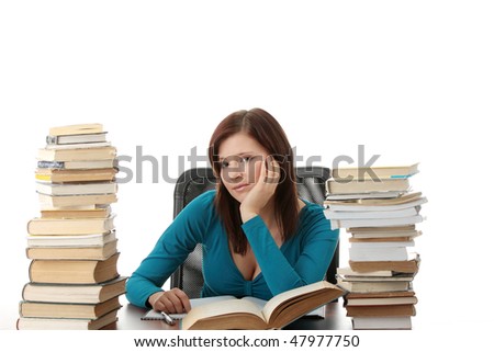 Teen girl learning at the desk with lot of books, isolated on white