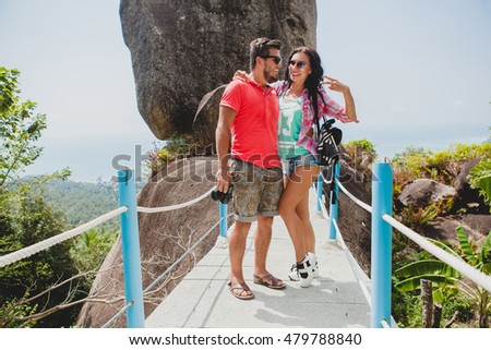 young happy hipster couple in love traveling around world, sightseeing, tropical romantic vacation in thailand, holding digital photo camera, smiling, happy, active tourism, summer