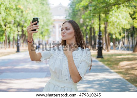 beautiful girl on the background of the city photographed themselves on the phone