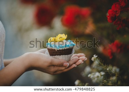 Bride is holding a colorful cupcake
