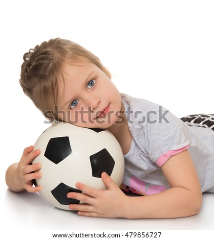 Adorable little girl lying on the floor . The girl put her head on a soccer ball. Close-up - Isolated on white background