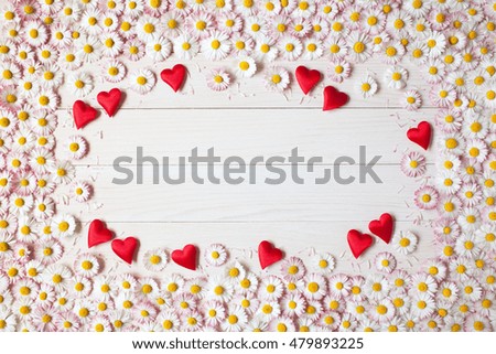 Wooden light background with daisies and hearts