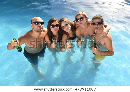 group of friends young happy attractive men and women in bikini having bath at hotel resort swimming pool drinking beer bottle having fun smiling playful  in boys and girls summer party and holidays