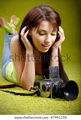 woman with camera on green spring background