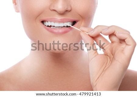Close up of female teeth and toothpick  Royalty-Free Stock Photo #479921413
