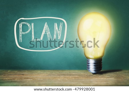 Plan text on board and light bulb on table