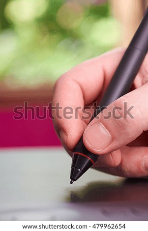 close up designer tablet pen in hand making sketch