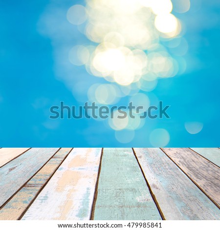 Perspective wood table top and blurry blue water bokeh abstract background, product display montage 