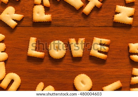 the word love written with alphabet cracker on wooden table