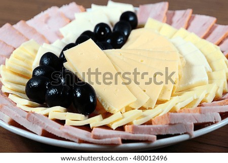 several kinds of sliced cheese and bacon on a plate