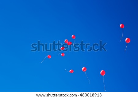 Red balloons flying on the blue sky