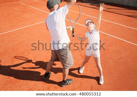 Tennis instructor with junior female talent on clay court