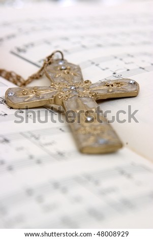 Closeup of a cross on top of notes