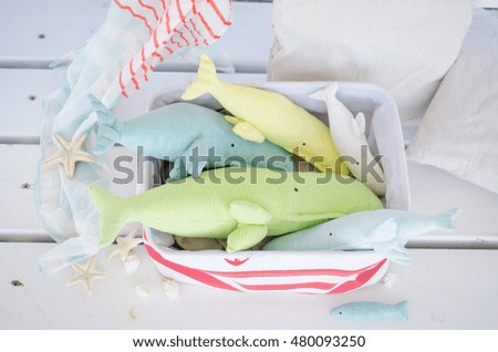 miniature vintage handmade toy whale on the white wooden floor background in the basket