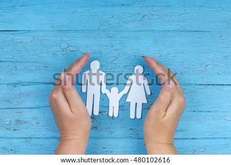 paper Family with safety hands on blue background, protection concept                                