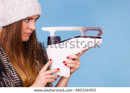 Winter, sport, people concept. Attractive lady with ice skates. Young woman wearing woolen cap.