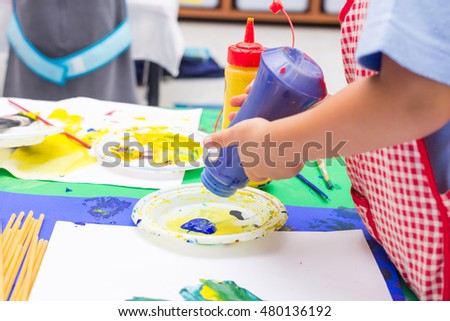 Hands of painting little  children and the table for creativity in selective focus