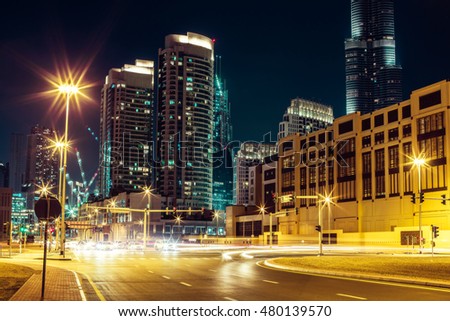 Fantastic nighttime skyline: big futuristic city with illuminated skyscrapers and crossroads. Dubai downtown, United Arab Emirates. Colorful travel background.