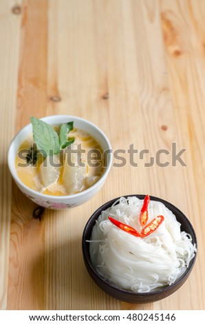 Thai vermicelli eaten with curry, Thai Food, rice vermicelli in black bowl on wooden table