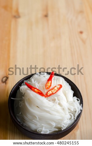 Thai vermicelli eaten with curry, Thai Food, rice vermicelli in black bowl on wooden table