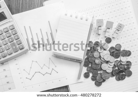 graph and note book on the wooden table with black and white color 