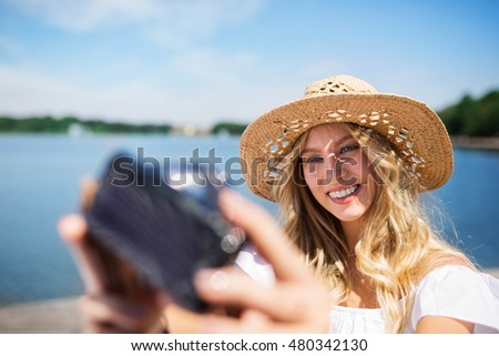 Girl taking a selfie at the lake
