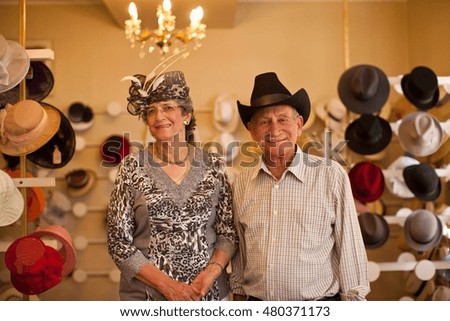 Portrait of senior couple in traditional milliners shop