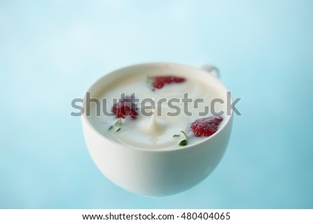 Ripples into a cup of milk with strawberries.