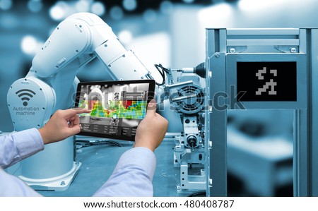 Industry 4.0 concept .Man hand holding tablet with Augmented reality screen software and blue tone of automate wireless Robot arm in smart factory background Royalty-Free Stock Photo #480408787