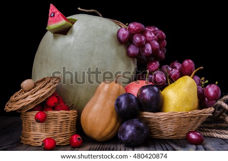 Pumpkin, watermelon and other autumn vegetables on a wooden background