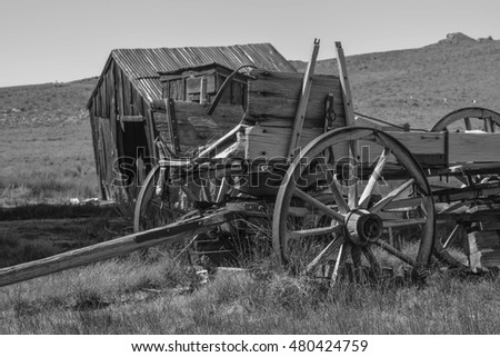 Old Wagon in Black and White: a black and white shot of an old wagon and an outhouse, in the historic town, Bodie