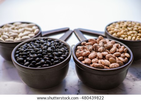 Beans variety/ different types of beans in ceramic bowls on black wooden background