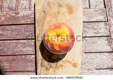 A peach on a cutting board with top view