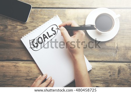 Goals memo written on a notebook with woman hand pen Royalty-Free Stock Photo #480458725